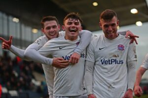 jonny-smith-centre-celebrates-with-luke-burke-and-jack-muldoon-after-scoring-fyldes-4th-of-the-game