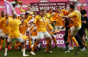 Liam Hughes, centre, celebrates winning the Conference Premier play-off final at Cambridge United