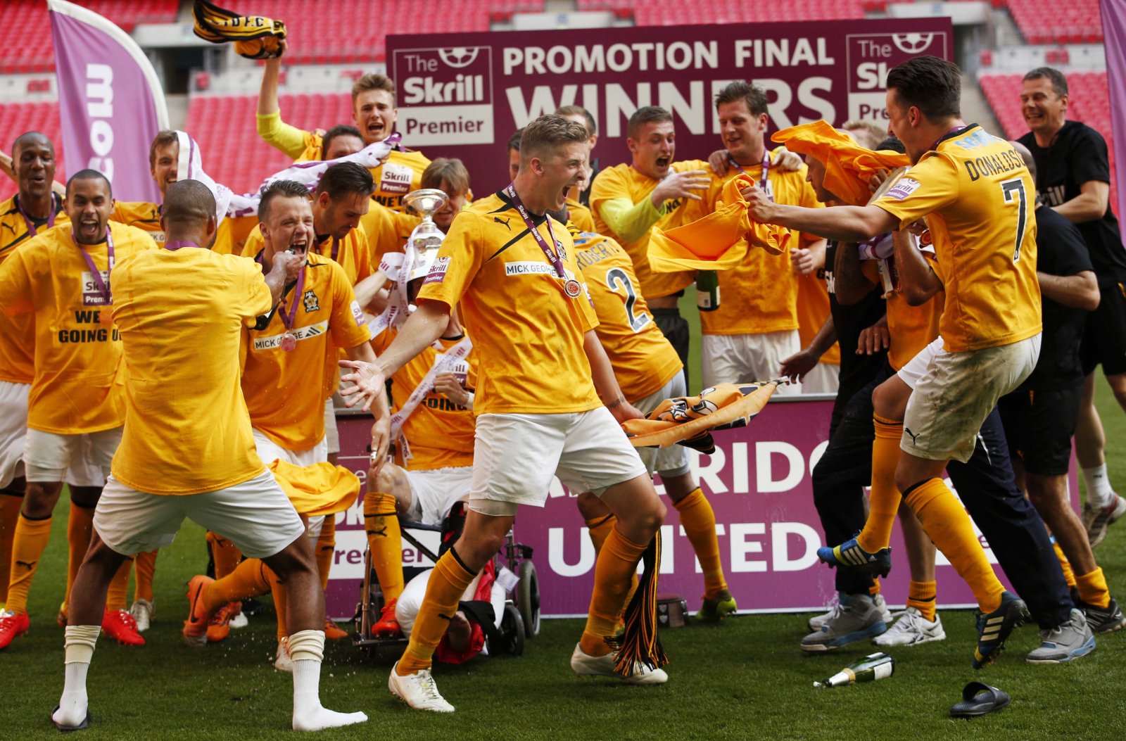 Liam Hughes, centre, celebrates winning the Conference Premier play-off final at Cambridge United