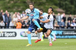 andy-monkhouse-of-grimsby-town-holds-up-the-ball-ahead-of-sam-cox-of-boreham-wood-during-the-vanarama-national-league-match-between-boreham-wood-an