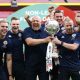 Alan Dunne, right, with Andy Woodman and the Bromley staff celebrating their FA Trophy win in 2022, holding the trophy together