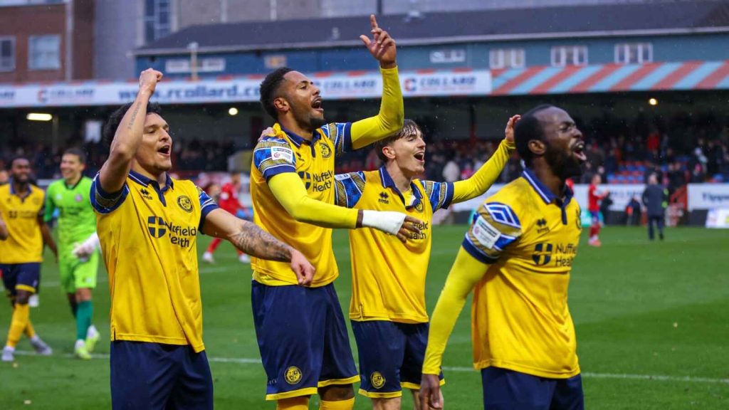 Josh Osude leads the celebrations after the final whistle for Woking