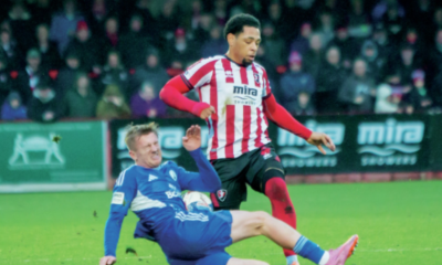 Buxton’s Luke Brennan tackles Cheltenham’s Arkell Jude-Boyd