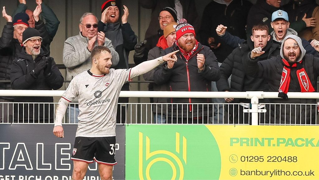 George Thomas celebrates after sealing Morecambe’s 2-0 win with his second goal at Brackley Town.