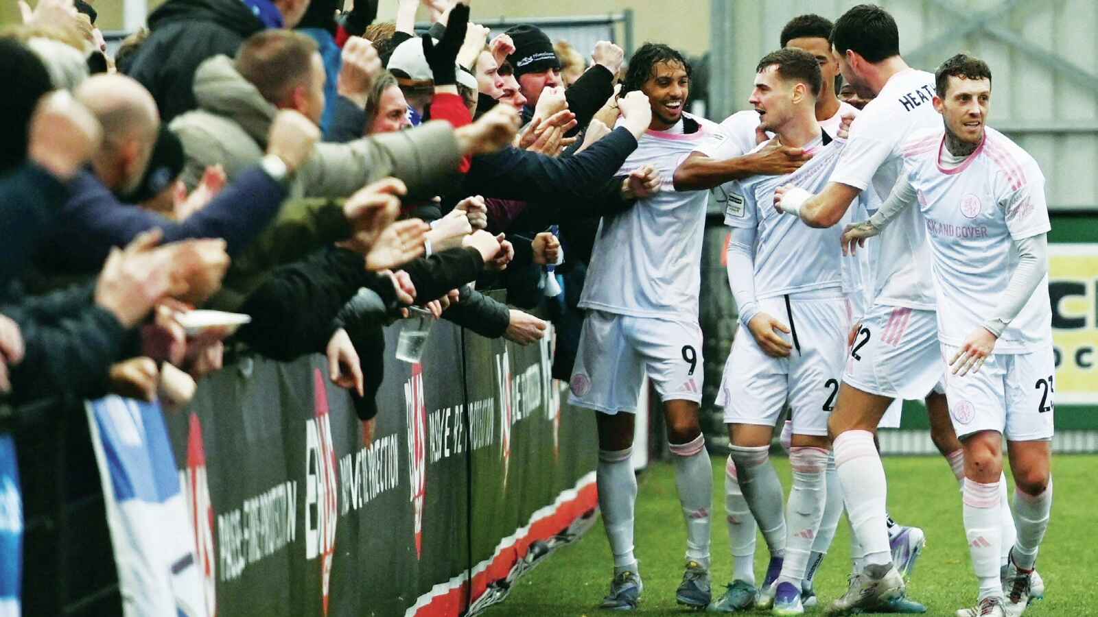 Macclesfield players celebrate James Edmondson’s fine second goal against Slough Town with fans. 