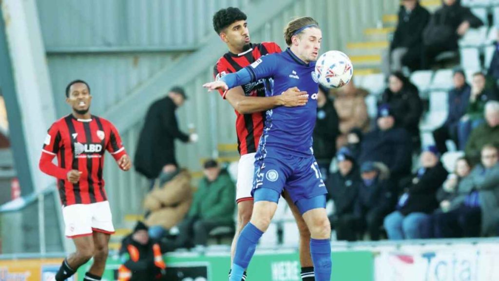 Morecambe’s Arjan Singh challenges Rochdale’s Joe Pritchard, right