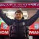 New Walton & Hersham manager Jakub Pietrzak holds aloft a Swans scarf