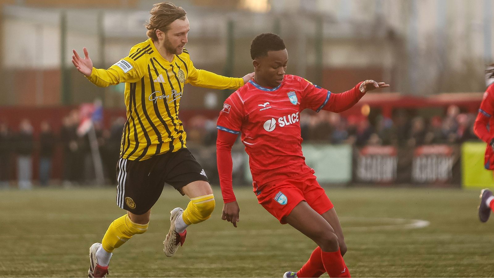 Morgan Roberts of Brackley Town chases Thabo Kuaho of Walton and Hersham for the ball during the Isuzu FA Trophy fourth round