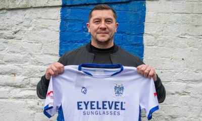 Bury’s new boss Anthony Johnson proudly holds up the club shirt on his first day in charge at Gigg Lane.