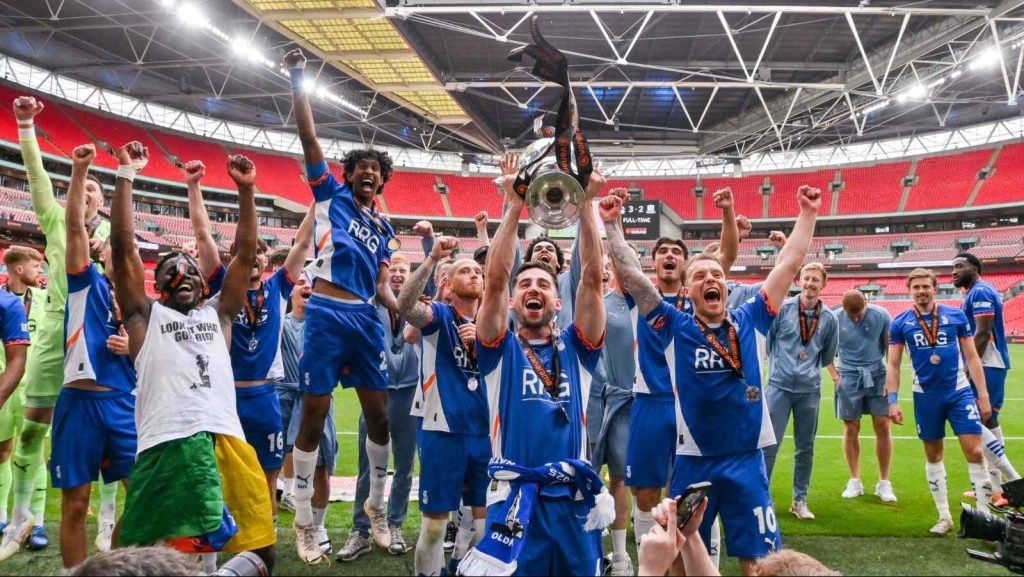 Oldham Athletic players celebrate with the trophy after winning last season’s National League play-off final at Wembley.