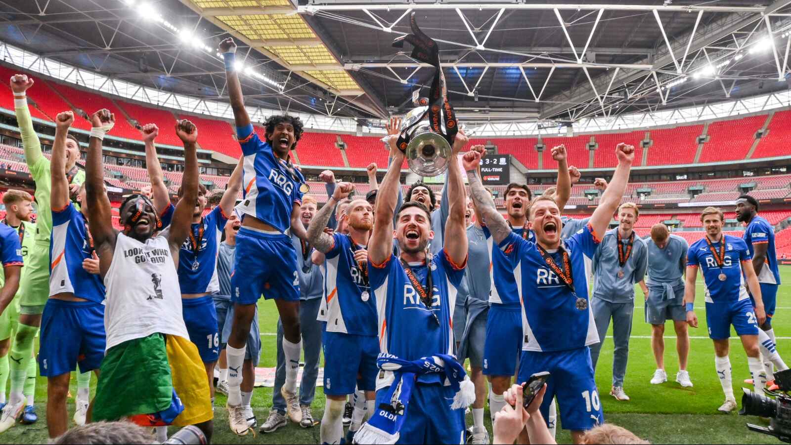 Oldham Athletic players celebrate with the trophy after winning last season’s National League play-off final at Wembley.