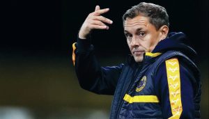 Paul Hurst on the touchline at Shrewsbury Town in 2024, and inset below, lifting the National League play-off final trophy with Grimsby Town