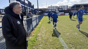 Danny Burkey watches on in his manager’s jacket
