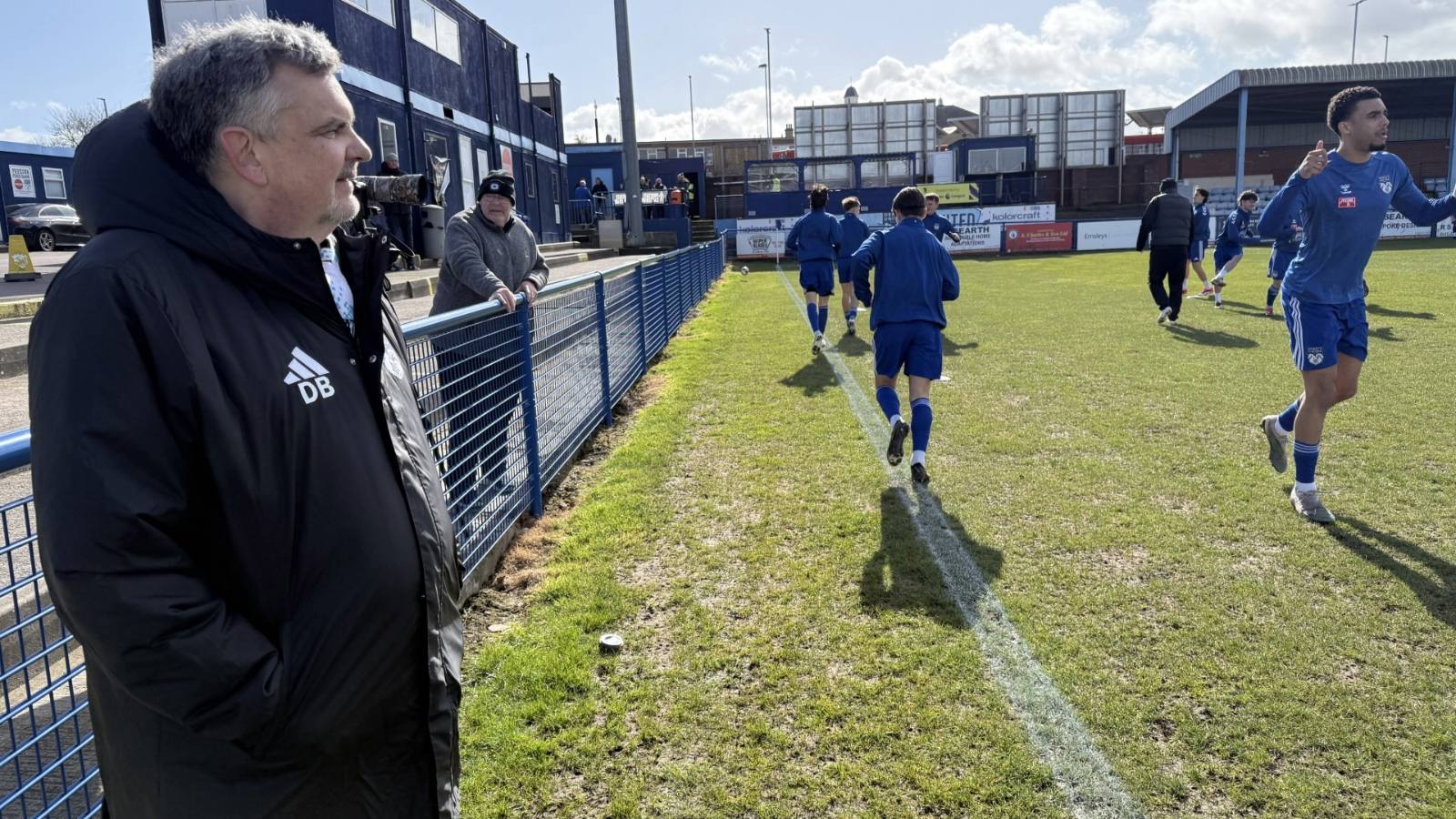 Danny Burkey watches on in his manager’s jacket