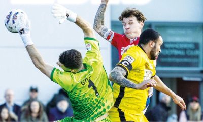 Chesham keeper Ben Goode and Dorking’s Alfie Rutherford meet mid air and, below, Dorking’s Kai Enslin makes advances in the midfield
