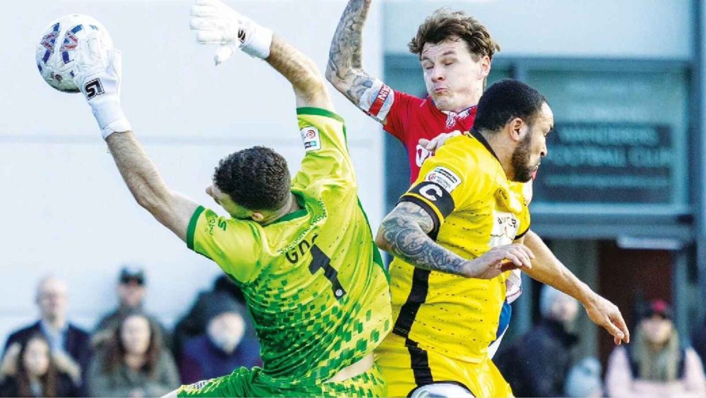 Chesham United keeper Ben Goode and Dorking Wanderers’ Alfie Rutherford meet mid air.