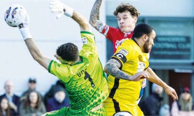 Chesham United keeper Ben Goode and Dorking Wanderers’ Alfie Rutherford meet mid air.