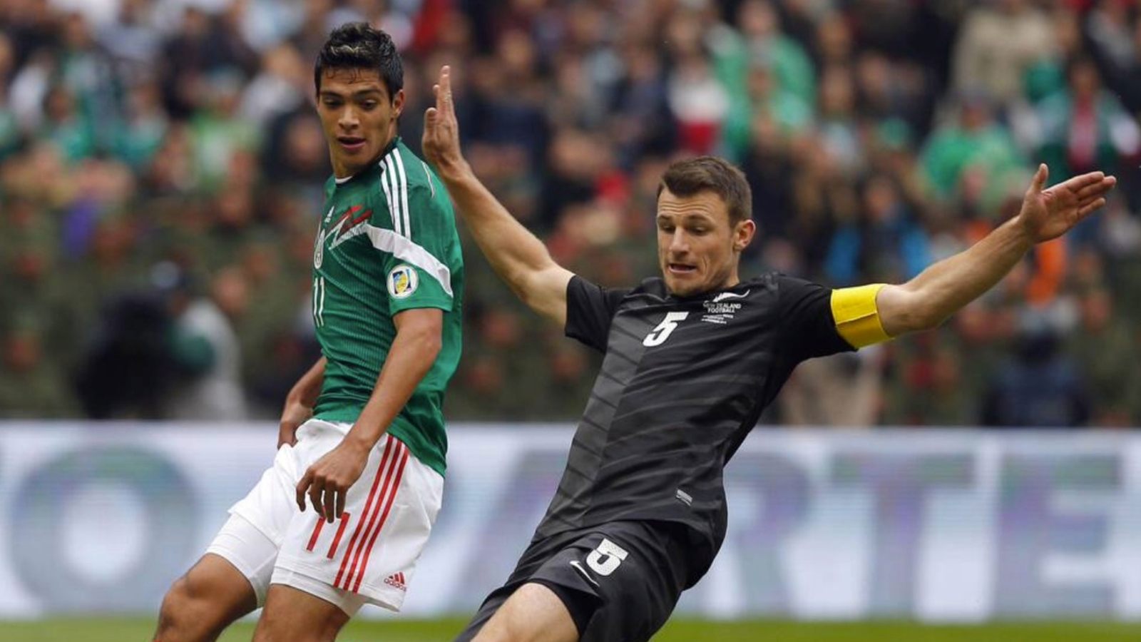 Tommy Smith, of New Zealand, lunges to thwart Mexico’s Raul Jimenez during a 2014 World Cup play-off game