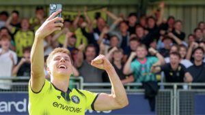 Harrogate Town striker Ciaran McGuckin celebrates his double with a selfie in front of the supporters