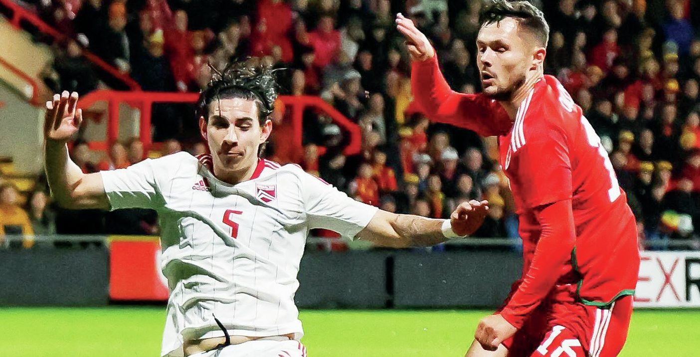 BIG STAGER: Louie Annesley, of Gibraltar, slides in to dispossess Wales’ Liam Cullen PICTURE: Alamy