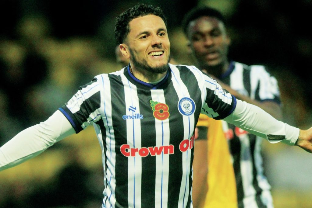 Tyler Smith wheels away after his brace helped continue Rochdale’s title charge