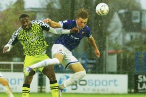 Forest Green Rovers' Temi Babalola, left, and Wealdstone’s Connor McAvoy battle in the rain