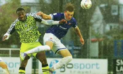 Forest Green Rovers' Temi Babalola, left, and Wealdstone’s Connor McAvoy battle in the rain