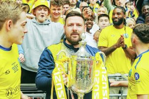 Jamie Tompkins celebrates winning Isuzu FA Vase Final trophy with Ascot United in 2023