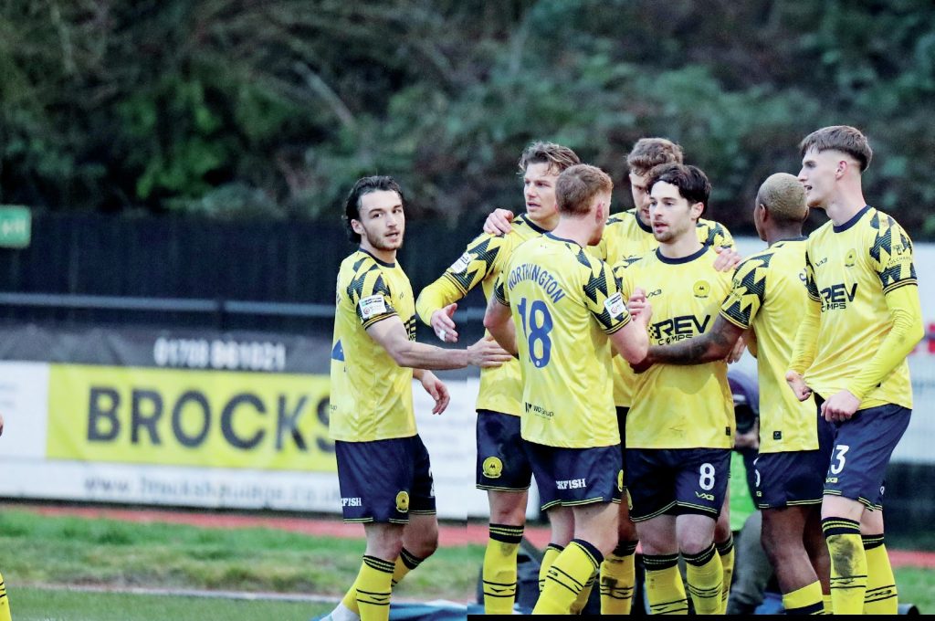Torquay United’s Jordan Young, middle, is mobbed after his second goal