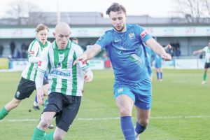 Blyth Town’s Ben Fell, in blue, son of manager Gavin, challenges Blyth Spartans’ Jack Foalle in the historic derby