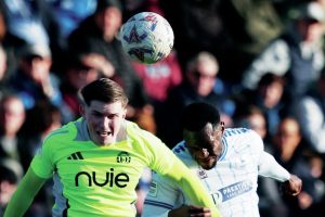 Hartlepool United’s Maxim Kouogun challenges for a header with Will Hugill of FC Halifax Town