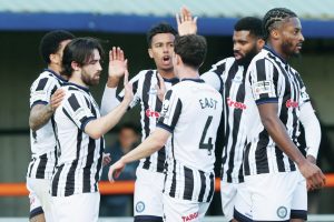 Rochdale players celebrate Aidan Barlow’s opener before the stoppage-time pandemonium