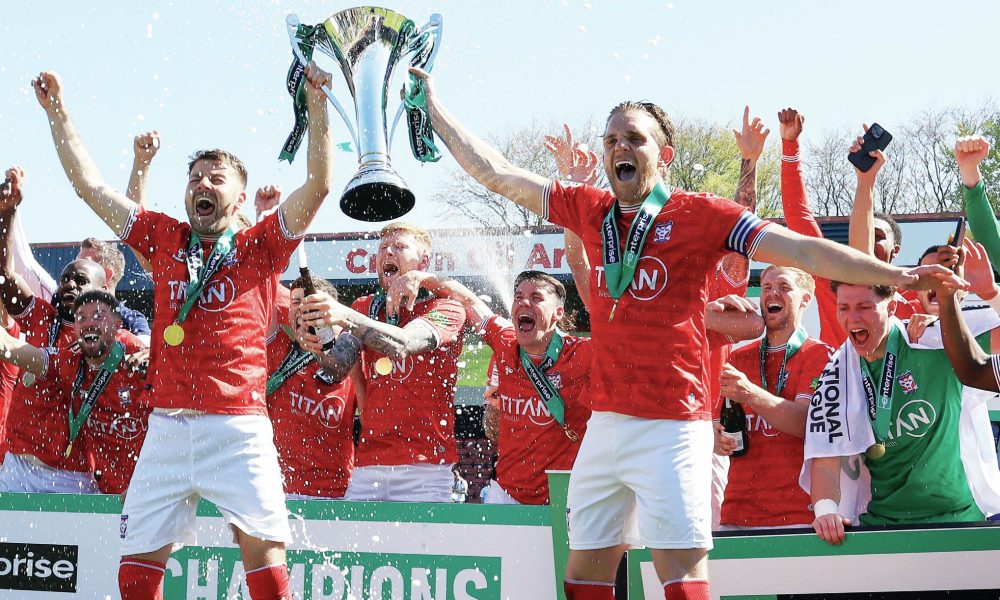 York City’s Ollie Pearce, left, and Callum Howe hoist the trophy high