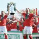 York City’s Ollie Pearce, left, and Callum Howe hoist the trophy high